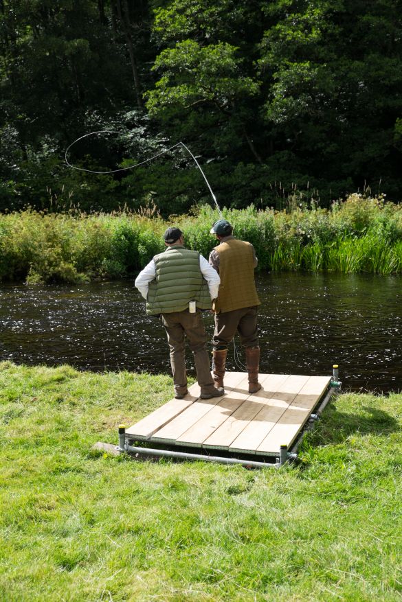 Man teaching another man to cast